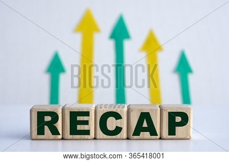 Word Recap On Cubes Against The Background Of Yellow Green Arrows. Business Concept