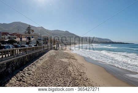 Cefalu, Sicily - February 11, 2020: Empty Sand Beach In Cefalu With A Nice Blue Sky And The Lungomar