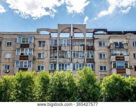 Worn Out Apartment Building From The Communist Era Against Blue Sky In Bucharest Romania.
