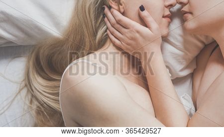 Equal Rights And Opportunities Concept. Lesbian Girls Gently Hug Each Other Lying In Bed, Top View