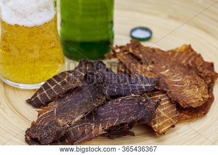 Dry Jerky Jerky For Beer. Beef And Jerky Chicken On A Wooden Background With A Glass Of Beer