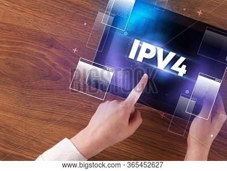 Close-up of a hand holding tablet with IPV4 abbreviation, modern technology concept