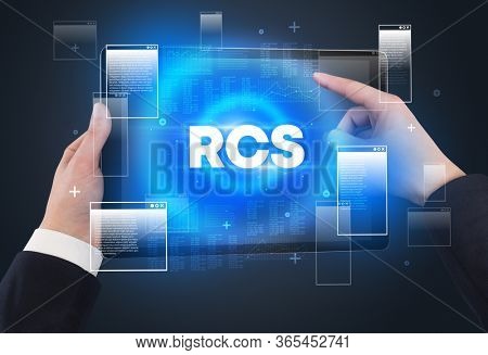 Close-up of a hand holding tablet with RCS abbreviation, modern technology concept