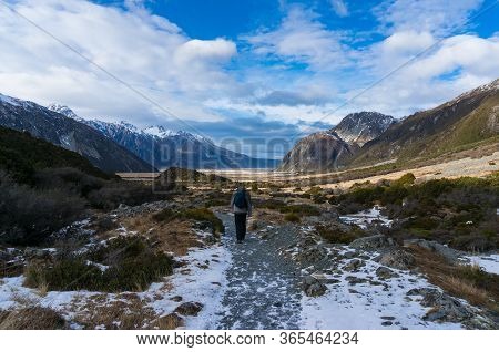 People Hiking. Winter Mountain Landscape With Foot Path And Snow Covered Mountains. Nature Tourism I