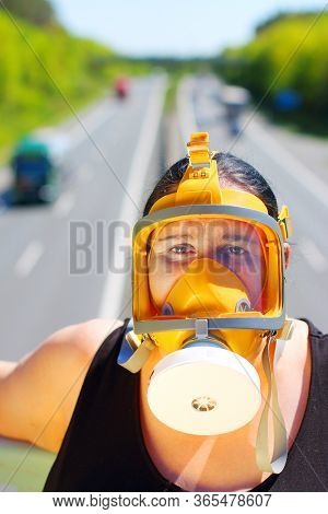 Woman with fullface respirator over street traffic. Health hazard from air pollution, allergy or infection. Protective clothing in action.