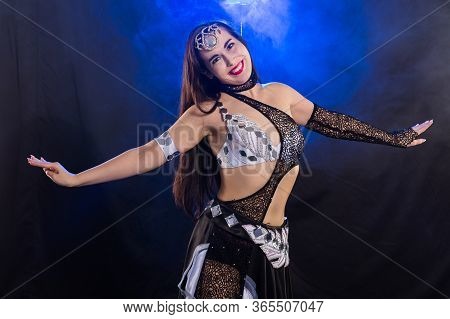 Girl Dancing Belly Dance, Fusion Or Tribal. A Woman In A Beautiful Costume Demonstrates Charming And