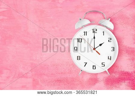 Old Fashioned Alarm Clock With Twin Bells And Ringer Showing 2 Oclock On Pink Background