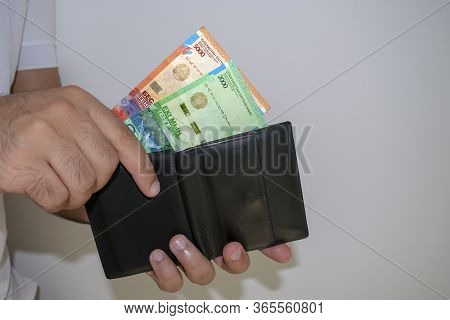 Kazakhstan National Currency. Kz Money Banknotes With Copy Space. Man Hand Puts Tenge Banknotes Into