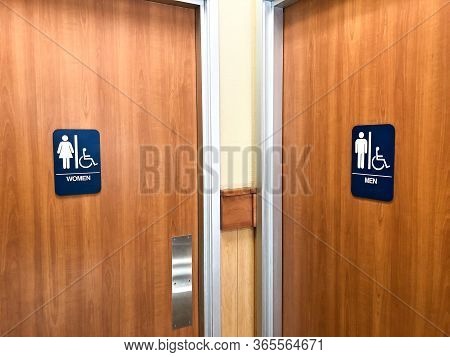 Two Public Restroom Doors With Blue Signs Specifying Male And Female With Handicap Accessible Featur