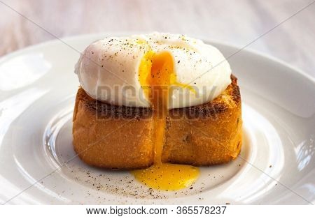 Close-up View Of Tasty Poached Egg With Liquid Yolk With Fresh Green Onion On Toastbread On White Pl