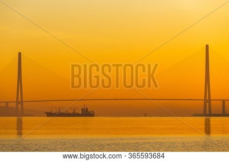 Dawn In The Sea City Of Vladivostok. Cable-stayed Russian Bridge Over Vostochny Bosphorus Strait To 