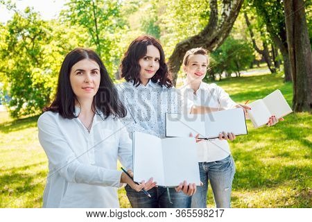 Young Beautiful Girls Drawing The Pictures In Sketchbook.