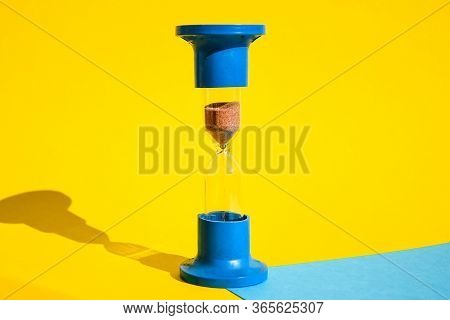 Hourglass Colored Background, Copy Space For Text, Hourglass Shows That Time Is Running Out