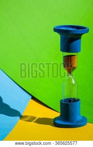 Hourglass Colored Background, Copy Space For Text, Hourglass Shows That Time Is Running Out