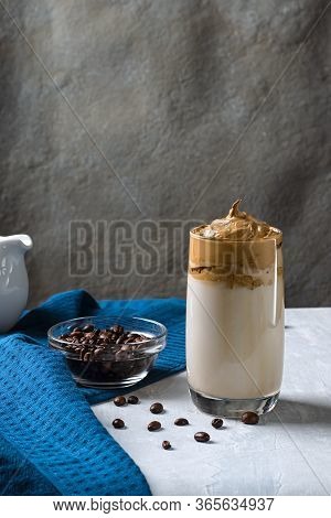 Dalgon Coffee - A Fashionable Drink Whipped Cream With Sugar. With Milk In A Cup On A Blue Backgroun