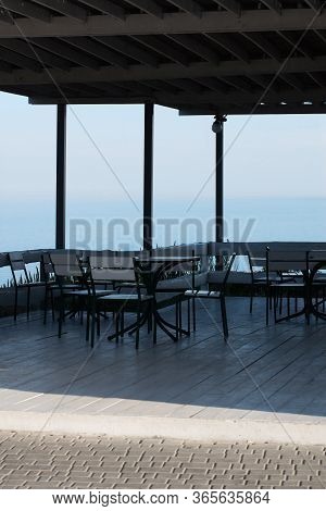 An Empty Terrace In A Summer Cafe With Tables And Chairs On The Sea Coast Without The Presence Of Pe