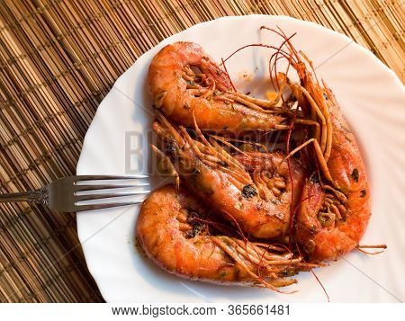 A Fried Lobster On A White Plate, A Straw Lining Under Plate, Fork, Garlic, Close Up