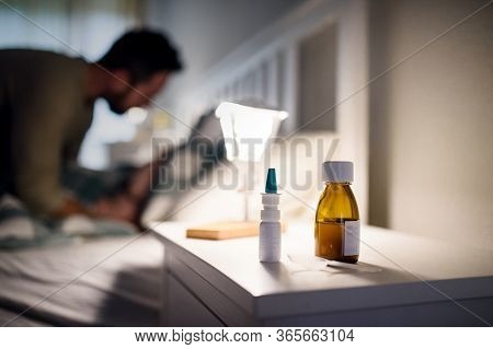 Bottle Of Syrup Medication On Bedsite Table At Home, Medicine And Sickness Concept.