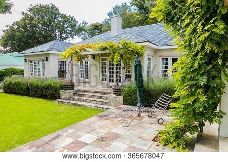 Patio Terrace Of Upmarket Wealthy Suburban Mansion House With Landscaped Garden