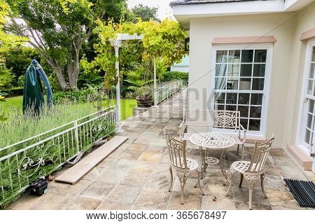 Patio Terrace Of Upmarket Wealthy Suburban Mansion House With Landscaped Garden