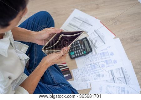 A Businessman Who Is Sitting On The Floor Of The House Opening The Wallet But Have To Pay Debt Calcu