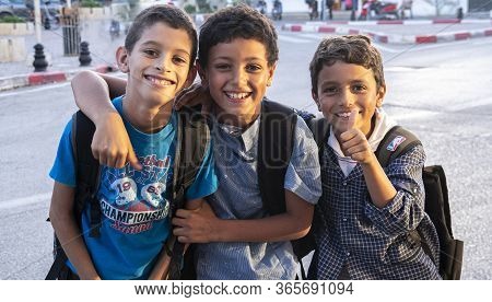 Mahdia, Tunisia - 03 October, 2019: A Group Of Three Arab Schoolchildren Are Looking At The Camera C