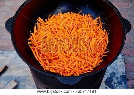 Preparation Of National Uzbek Dish Pilaf, Pilaw, Plov, Carrot With Meat In Big Pan. Cooking Process,