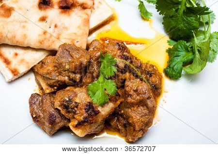 Naan e Lamb Curry Cirrander fecham para cima em uma placa branca