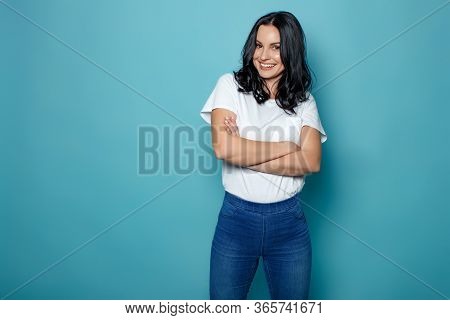 Young Woman In The Studio On A Blue Background Conveys Different Emotions. Beautiful Woman In Jeans 