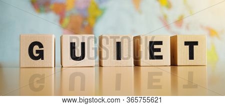 The Word Guiet Symbol Written On Wooden Cubes Isolated On A Political Map Background