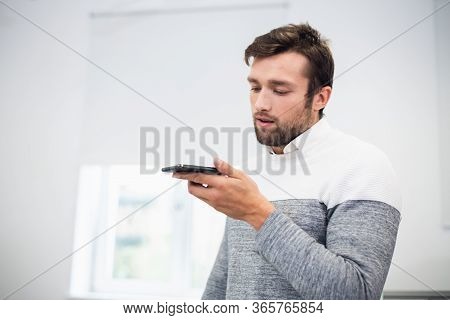 A Portrait Of An Office Worker Talking To Someone Using The Spea