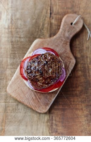 Tasty Humburger With Tomatoes And Red Onion. Rustic Stone Background. Top View.
