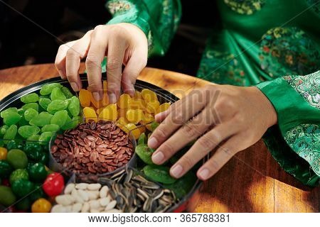 Hands Of Vietnamese Man In Traditional Costume Taking Dried Snacks From Mut Plate
