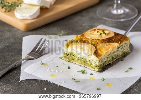 Zucchini Pie Or Quiche With Goat Cheese On Wooden Cutting Board. Slice Of Goat Cheese Near It. Healt