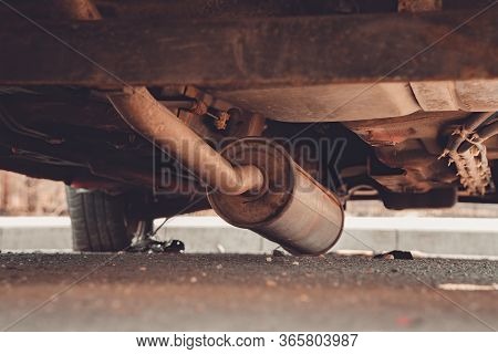 Car Exhaust, Muffler Fallen Down On The Ground - View Of Rusty Chassis Of A Car