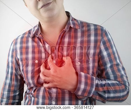A Man Grabs His Chest In The Region Of The Heart. Heart Attack Or Chest Pain. The Concept Of Heart D