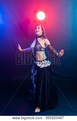 Girl Dancing Belly Dance, Fusion Or Tribal. A Woman In A Beautiful Costume Demonstrates Charming And