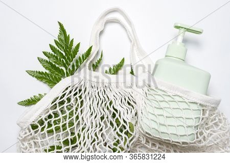 Green Container For Shampoo, Conditioner Or Liquid Soap In Eco Bag With Green Leaves. String Bag Or 