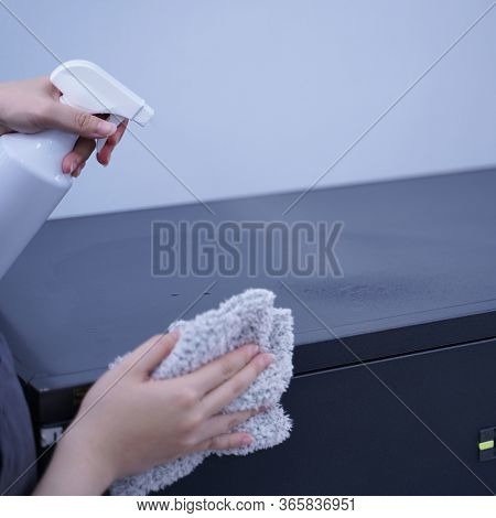 Young Woman Is Holding Spray Bottle, Rag To Clean, Wipe Down Office Metal Cabinet Shelf Accommodatio