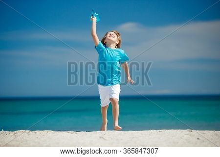 Child Boy Plays At Sea With An Airplane. Dream To Travel.
