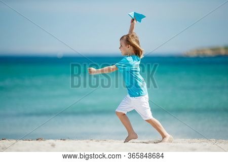 Child Boy Plays At Sea With An Airplane. Dream To Travel.