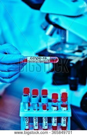 COVID-19. Doctor, microbiologist, scientist in a protective suit, makes a research on blood samples of infected people in the laboratory. Coronavirus test.
