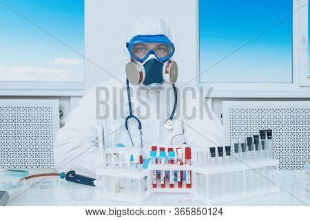 COVID-19. Doctor, microbiologist, scientist in a protective suit, makes a research of coronavirus in the laboratory. Modern technologies in medicine.