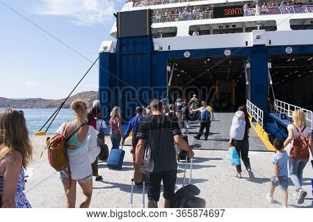 Ios - Cyclades - Greece - October 3 2018 : Passengers Walk Along The Dock To The Ramp Of A Ferry On 
