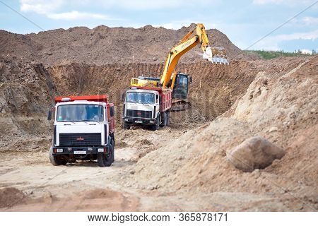 Grodno, Belarus - May 2020: Two Multi-ton Mining Maz Trucks In Process Of Loading Ore By Hyundai Exc