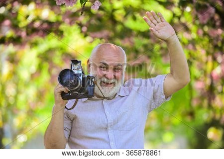 Professional Photographer. Pension Hobby. Senior Man Photographer Blooming Trees Background. Cameram