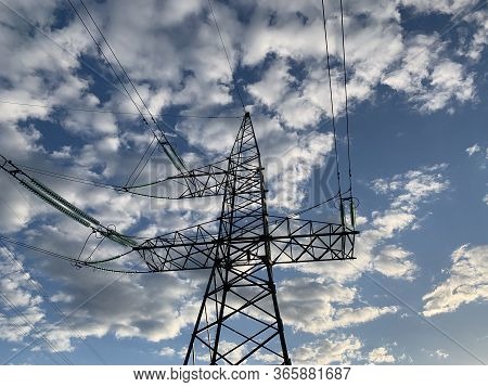 High Voltage Electric Tower Against The Blue Sky. High Steel Power Pole, Among The Forest. High Volt