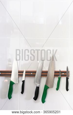 Magnetic Strip With Collection Of Knives. Hanging Magnetic Strip With Set Of Sharp Knives