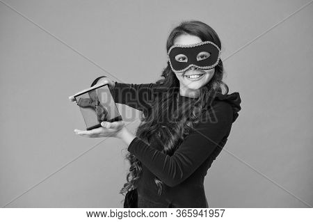 Winter Carnival. Secret Santa Gift Concept. Kid Wear Eye Mask. Girl In Mask Orange Background. Winte