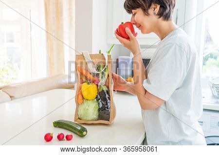 Woman Taking And Checking Fresh Organic Vegetables From Reusable Eco Sackcloth Fabric Bag Packaging 